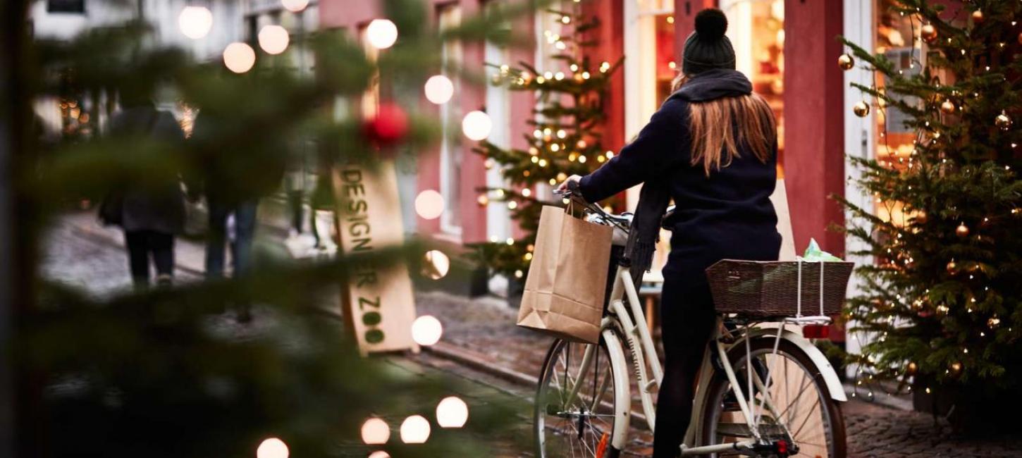 A girl rides a bike through a Christmassy street in Aarhus, Denmark