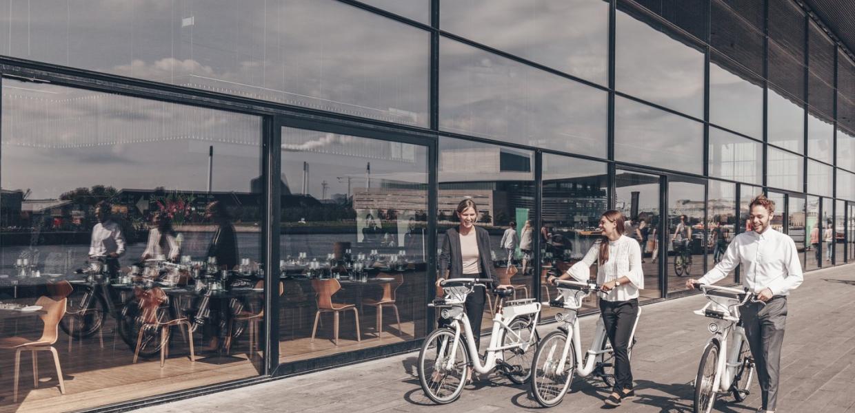 People walking outside the Royal Danish Playhouse "Skuespilhuset" with city bikes, Copenhagen