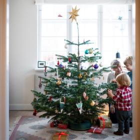 Familie dekoriert gemeinsam einen dänischen Weihnachtsbaum